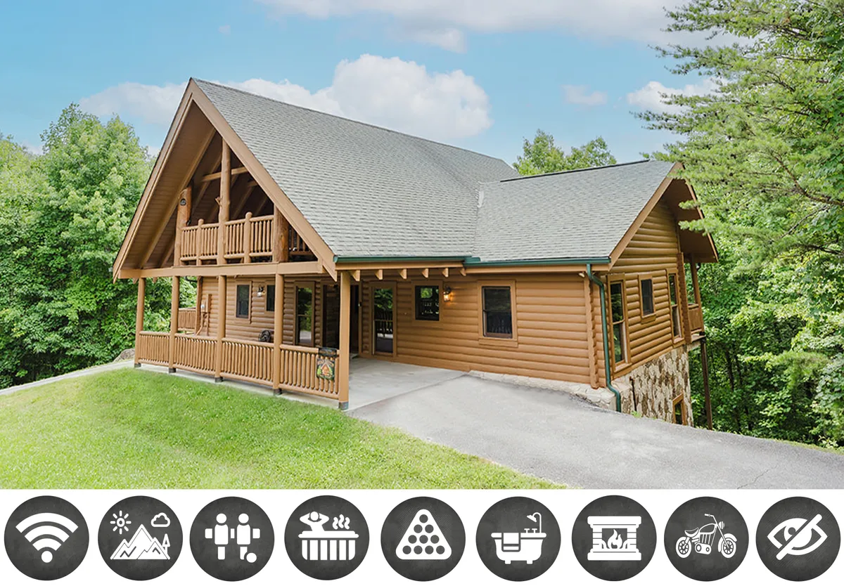The image showcases a beautiful log cabin nestled among lush greenery, with a spacious balcony overlooking the Smoky Mountains. Warm light spills from the windows, hinting at a cozy interior, while the expansive outdoor space invites guests to gather and take in sweeping sunset views.