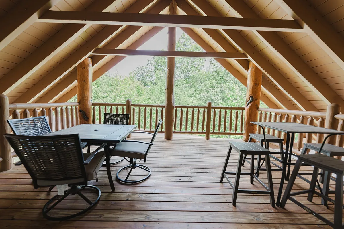 A cozy interior dining area with wooden beams and a wide view of the lush outdoors through large windows. The table setup and nature views make this spot ideal for enjoying meals while still feeling embedded in the natural surroundings.